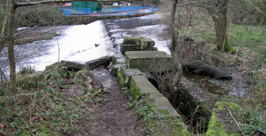 The long weir at Hollins Bridge Mill, with what may be the remains of the intake / shuttle for the waterwheel. Photo: Sue Shaw, February 2014.